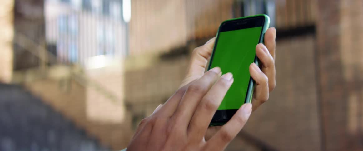 Close up of a womans hand touching a cell phone with a blank screen