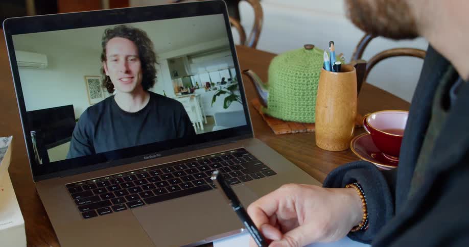 Two friends on a laptop video call at home