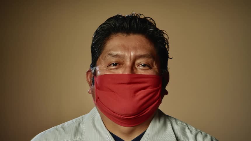A man is wearing a face mask indoors
