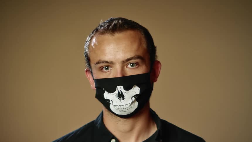 A man is wearing a face mask indoors