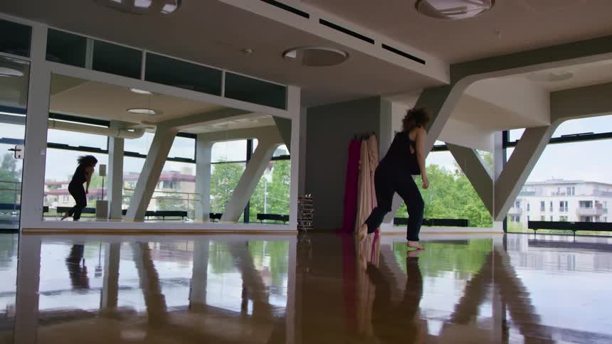 A woman is dancing in an empty room