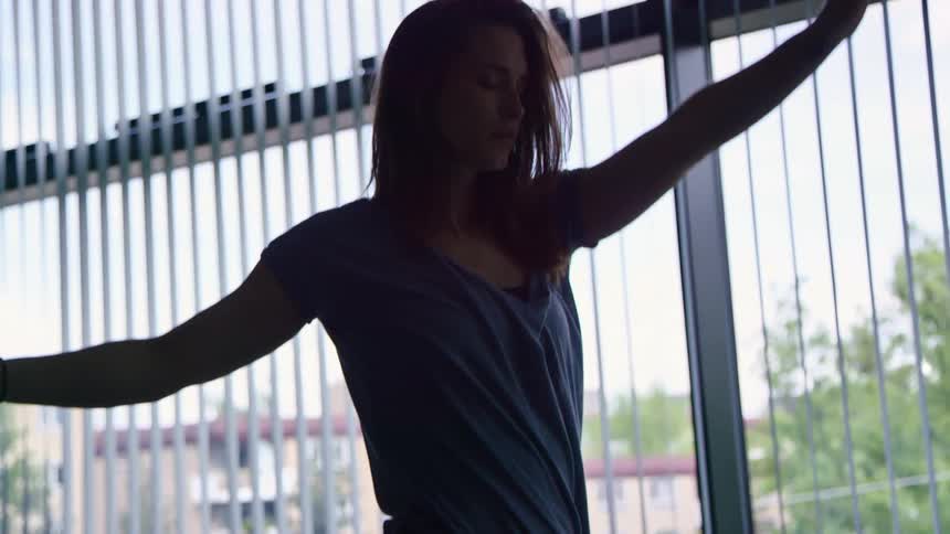 A woman is dancing in a building during the day