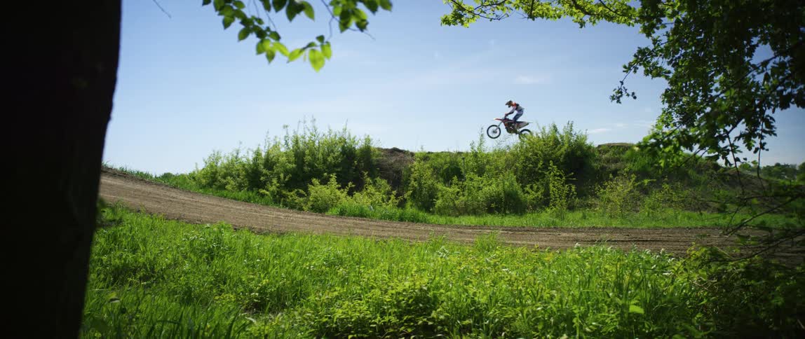 A person does a large jump on his dirt bike