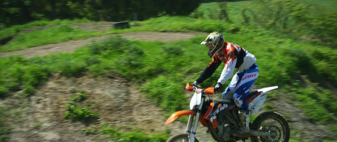 A man rides his motorcycle over jumps