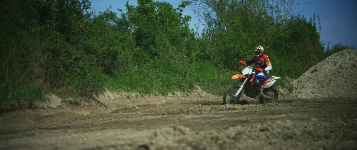 Man rides dirt bike on the race track at day