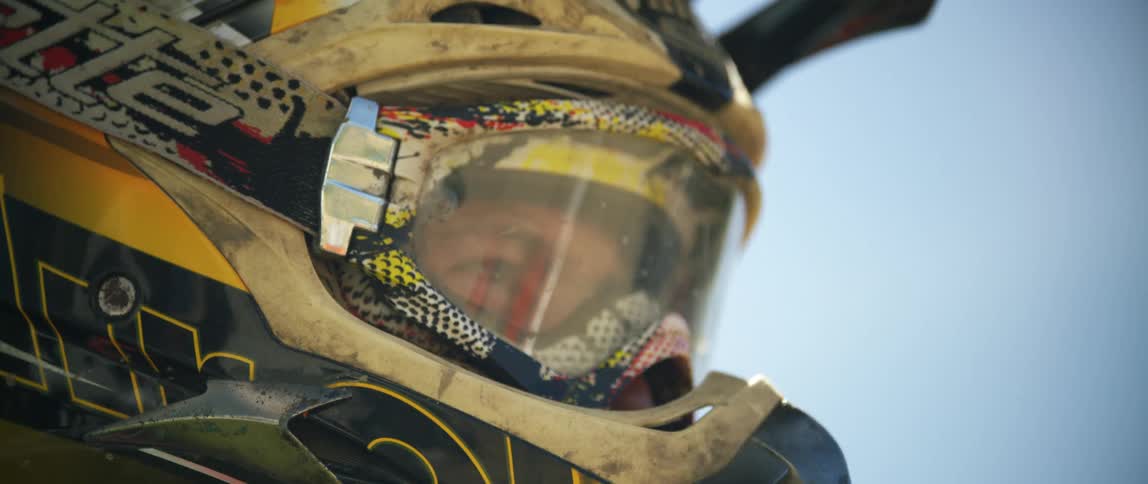 Close up of a mans head wearing a motocross crash helmet and goggles
