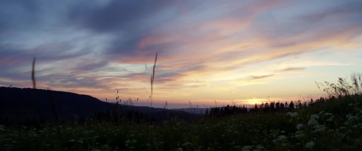 The sun sets over the plains and hills of the grassland