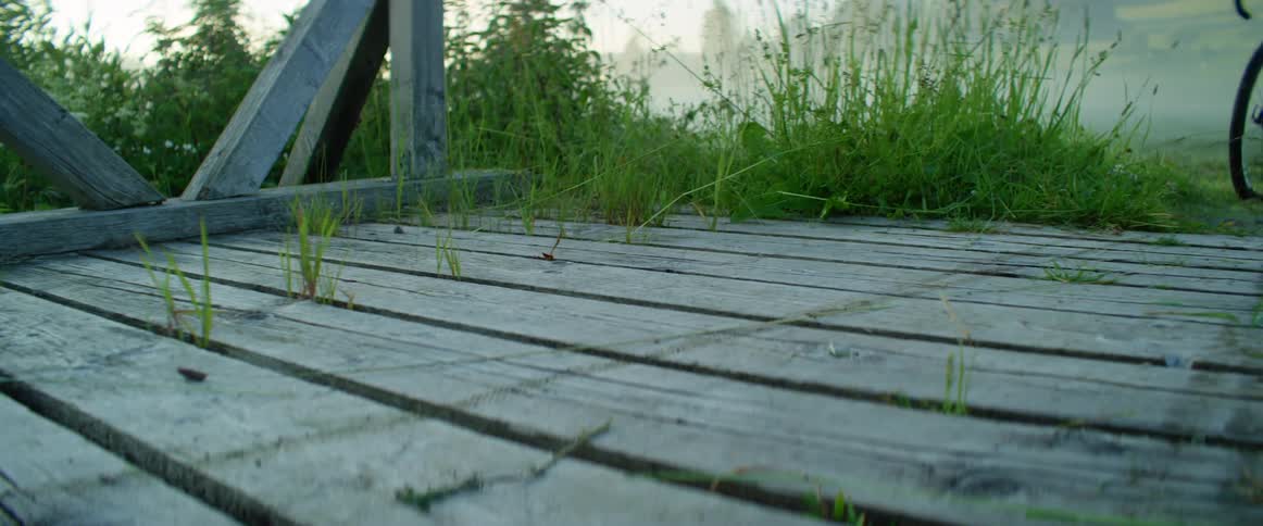 A cyclist rides a bicycle onto a wood plank pier