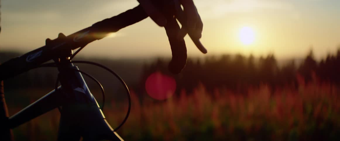 A bicyclist stopped to look at a sunset