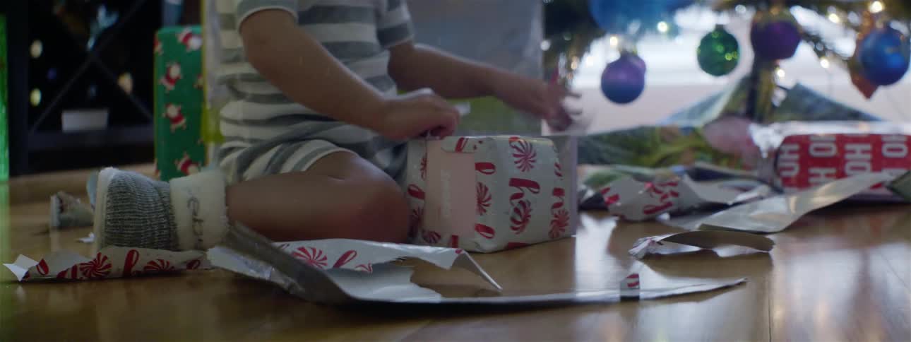 A young child opens a christmas present