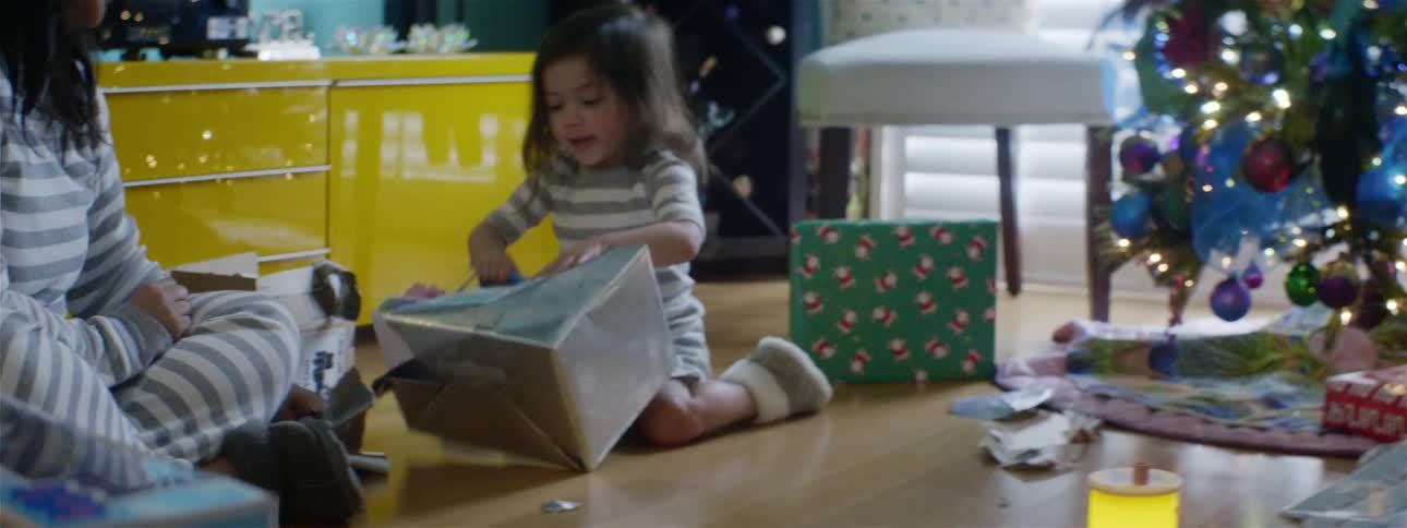 A father records his daughter opening a christmas present with his smartphone