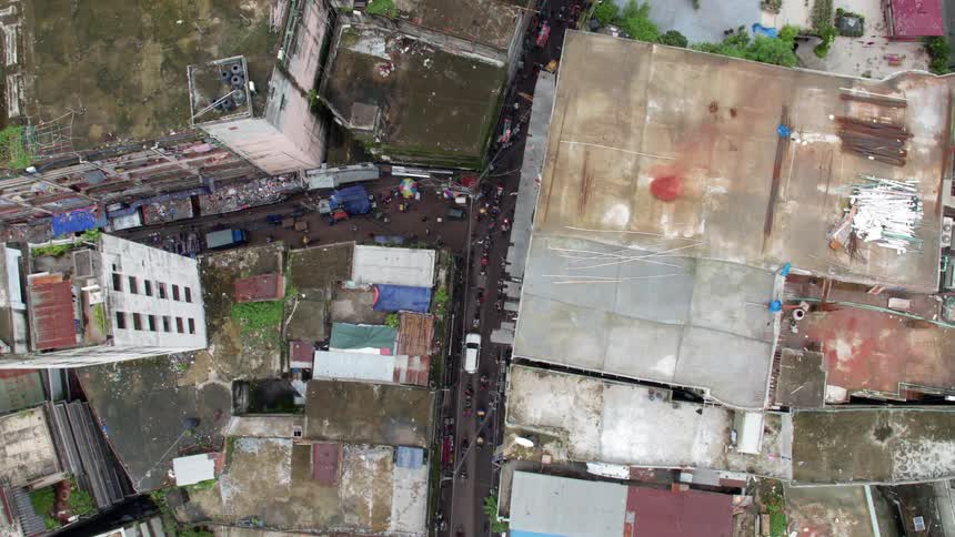 Aerial view of people walking and cars driving in a poor neighborhood