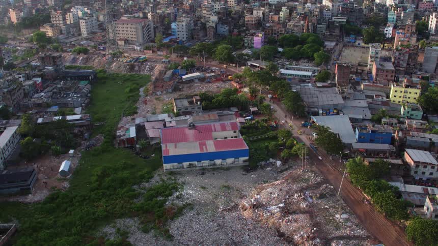 Traffic drives along street through city and past landfill