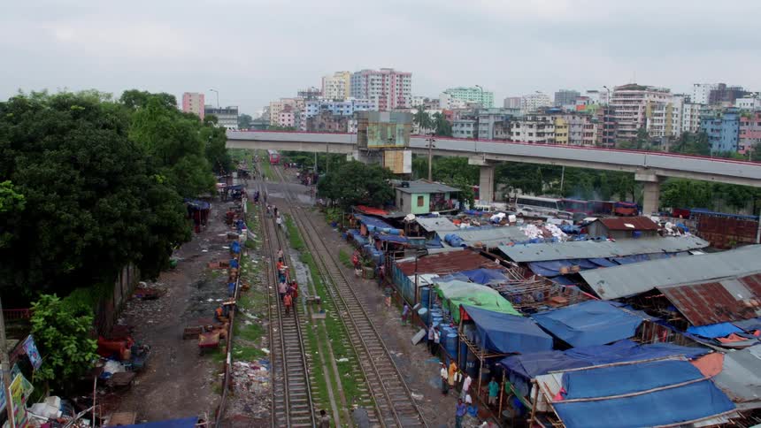 People are walking over the train tracks by the city