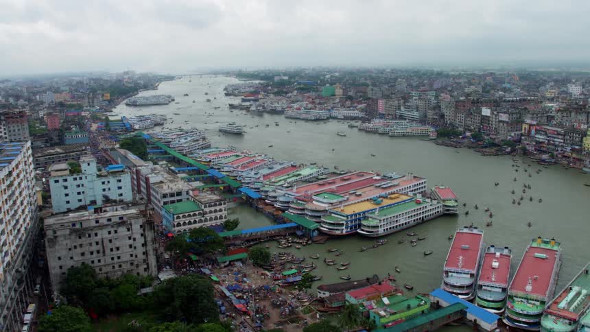 An aerial view of a city on the shore with the water filled with boats