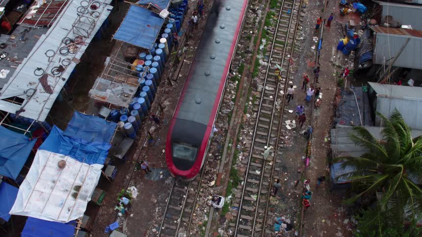 Train drives through an impoverished third world country slum