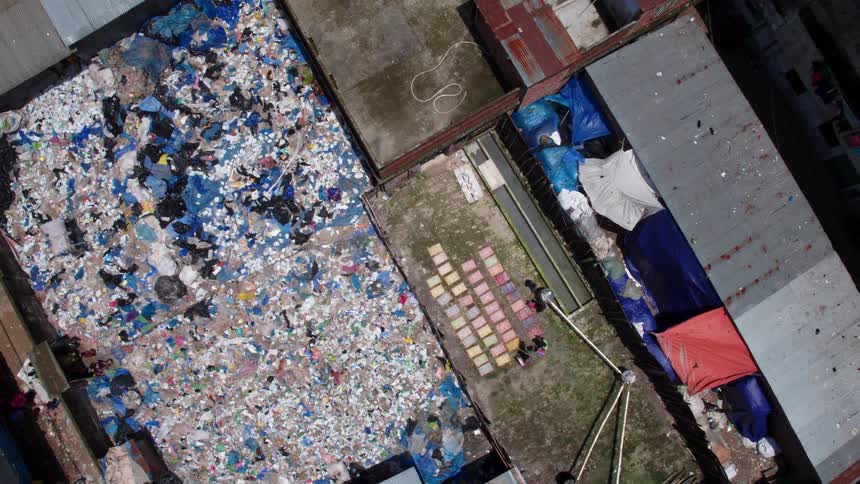Birds eye view of people in a primitive area picking through garbage