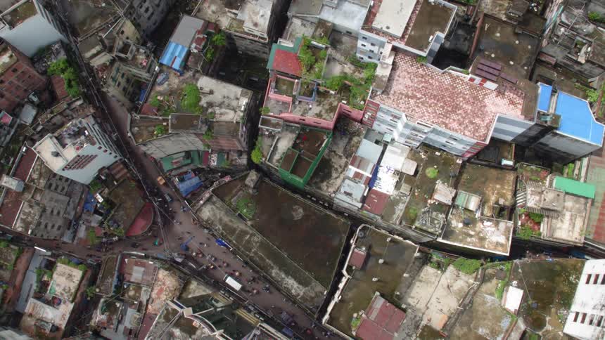 Birds eye view of cars driving past housing in a neighborhood