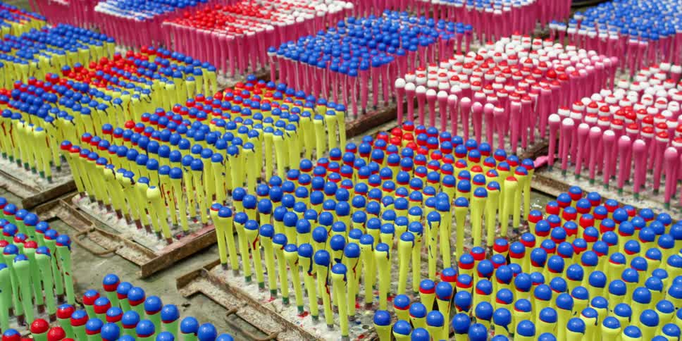 Plastic bat shapes occupy wooden pallets placed in rows and columns