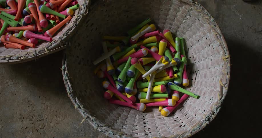 Colorful balloons falling into a wicker basket in a third world country factory