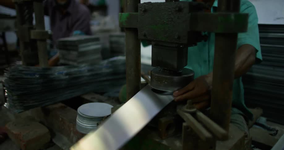 Men in a factory cut circles in steel