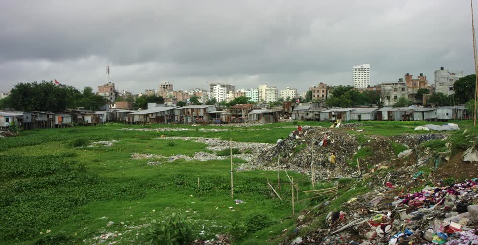 Kids climbing on piles of garbage in front of a neighborhood