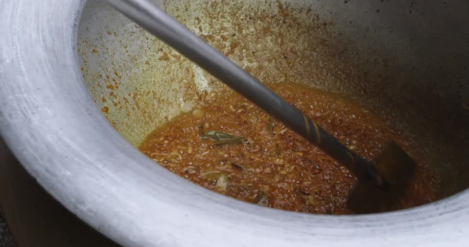 Food in large cook pot being stirred