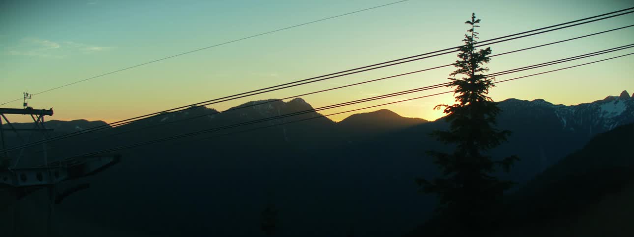 Tower of a cable car in the mountains at sunset