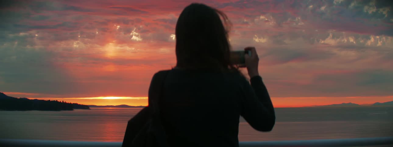 A woman is watching the sunset outdoors