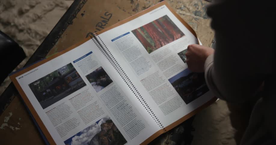 A person flips through a book with photos and text