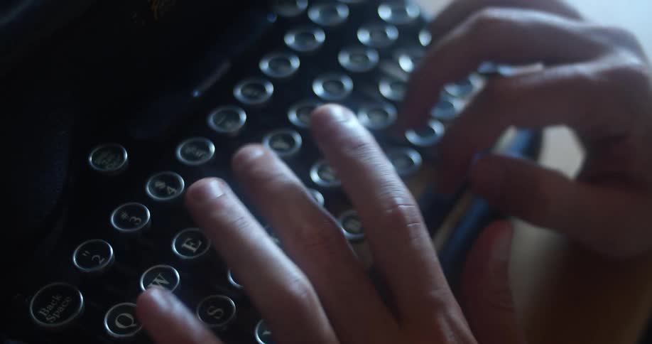 A man typing on a vintage typewriter