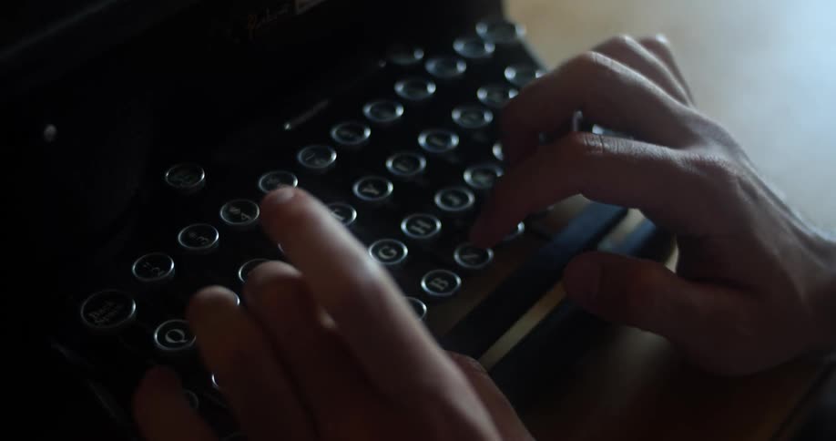 A man typing on a vintage typewriter