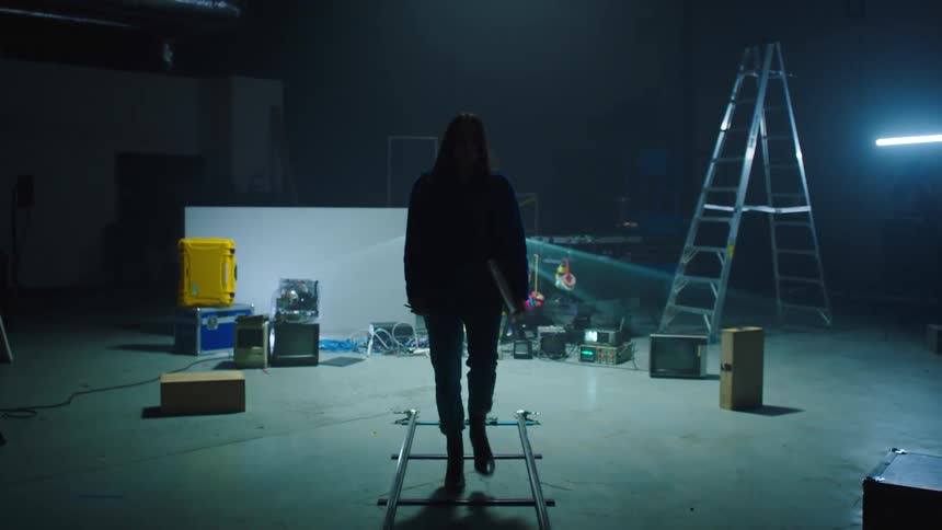 A woman walks on a stage that is being set up for a performance