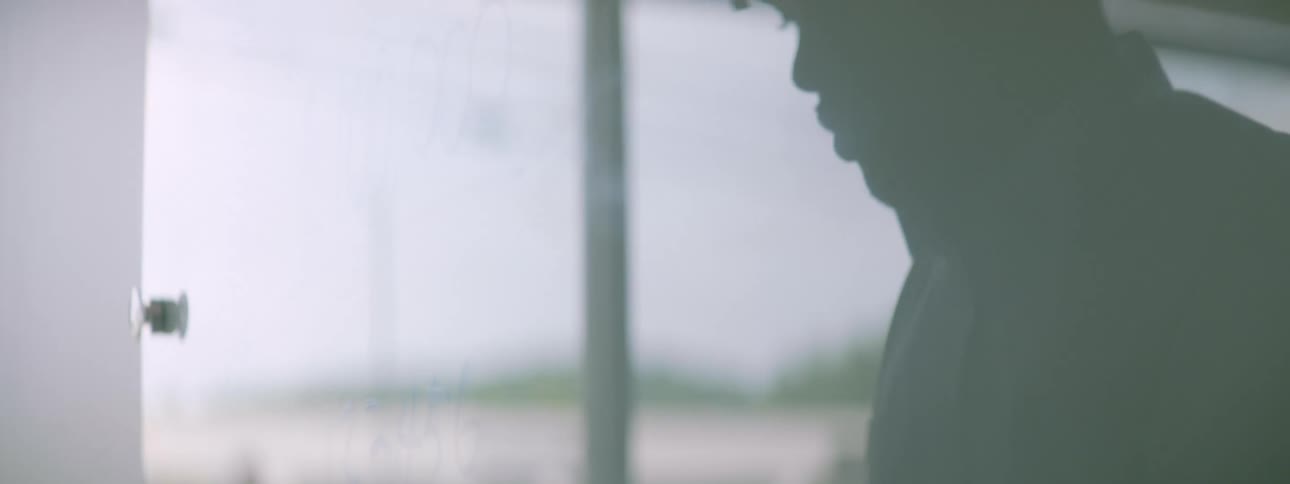 A man uses a blue marker to write on a white board