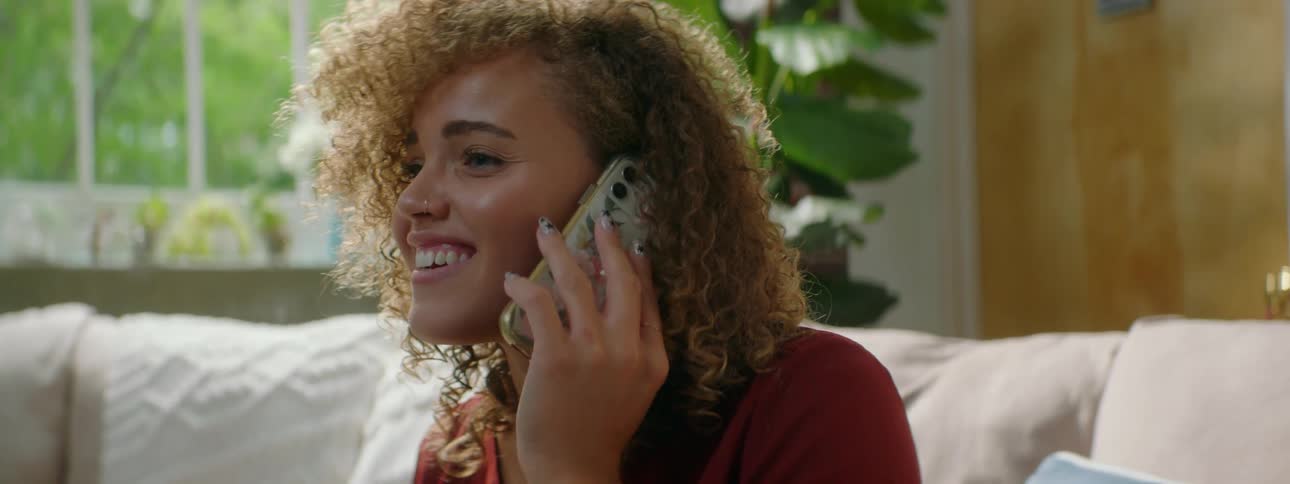 A teenage girl at home talks on her cell phone