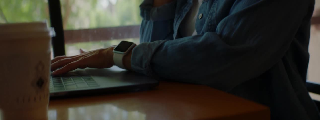 A woman is talking on a cellphone while sitting at a table