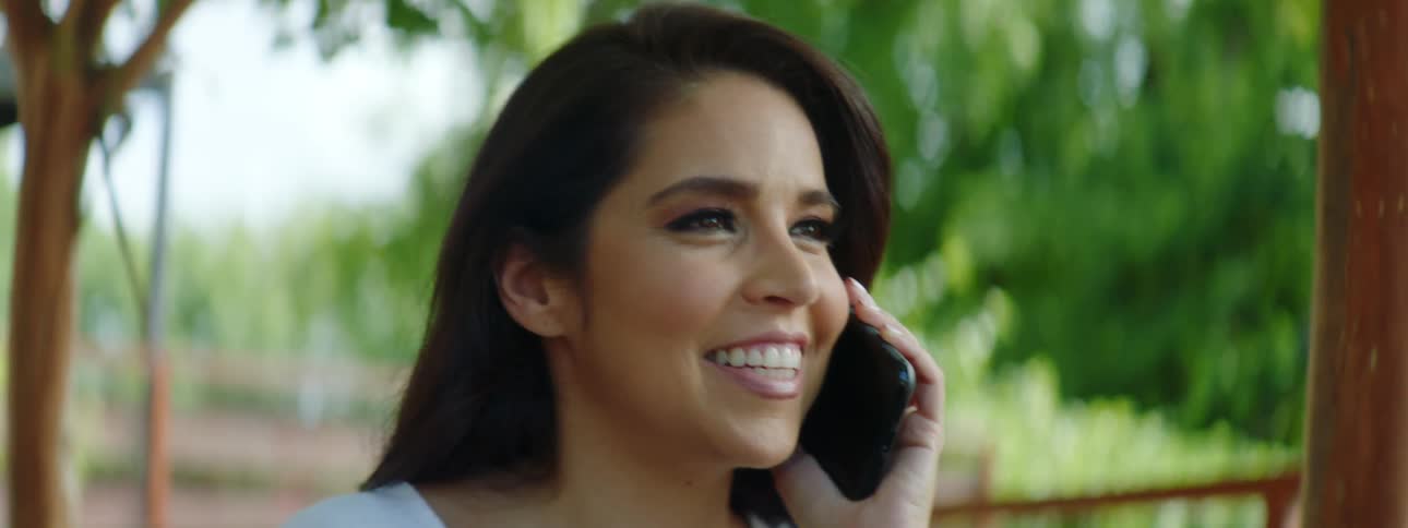 A woman is talking on a cellphone outdoors in spring