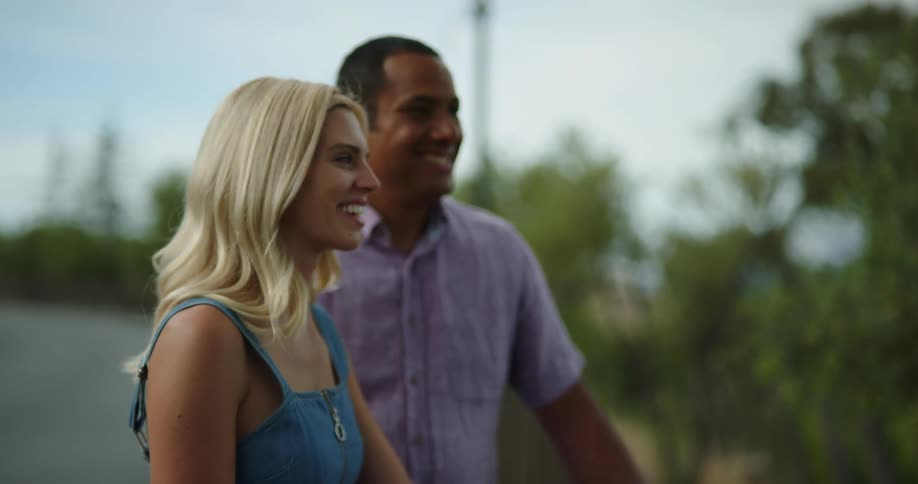 A couple in a date talking and laughing outdoors