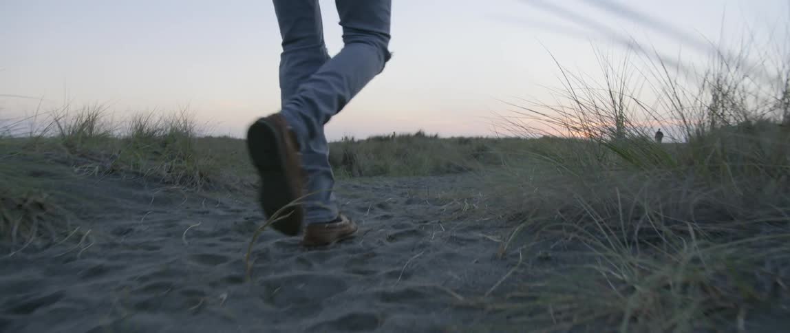 A man walking through sand