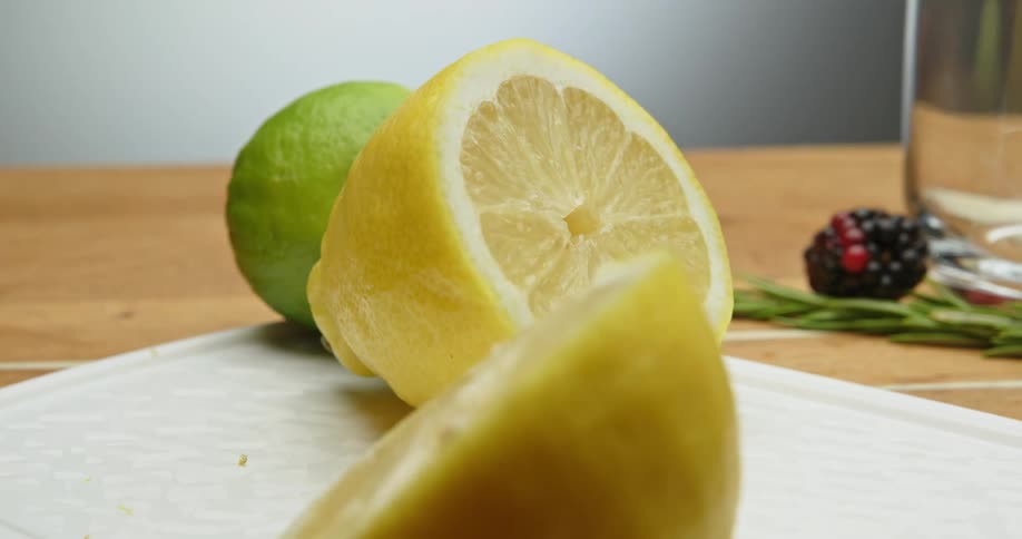 Yellow lime cut in half over a cutting board in a table