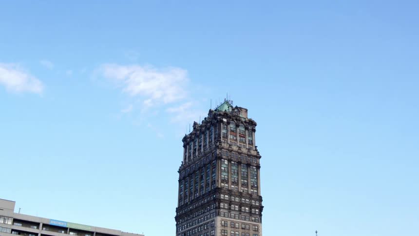 A building with windows in a city with the sky and clouds in the background