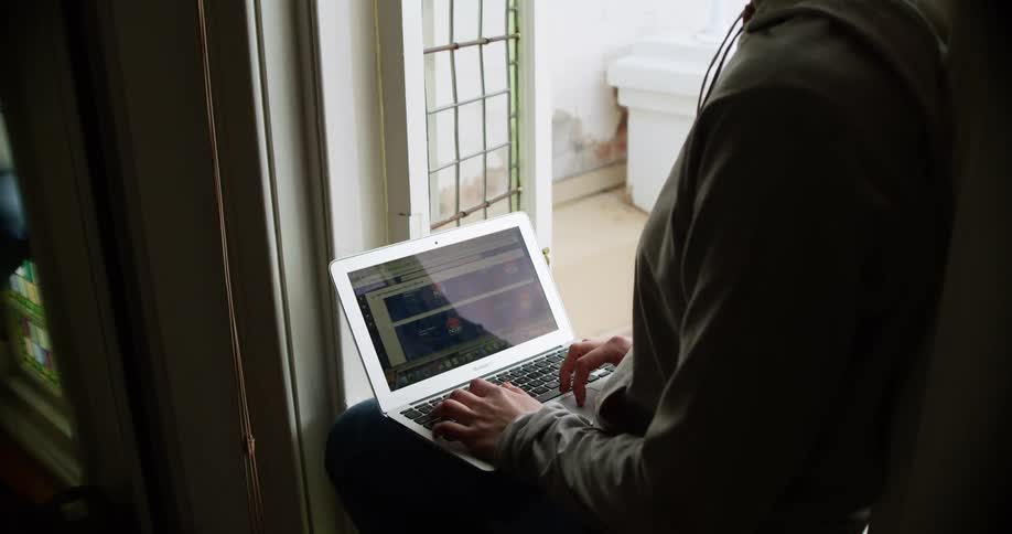 Woman with glasses and a grey hoodie uses macbook air