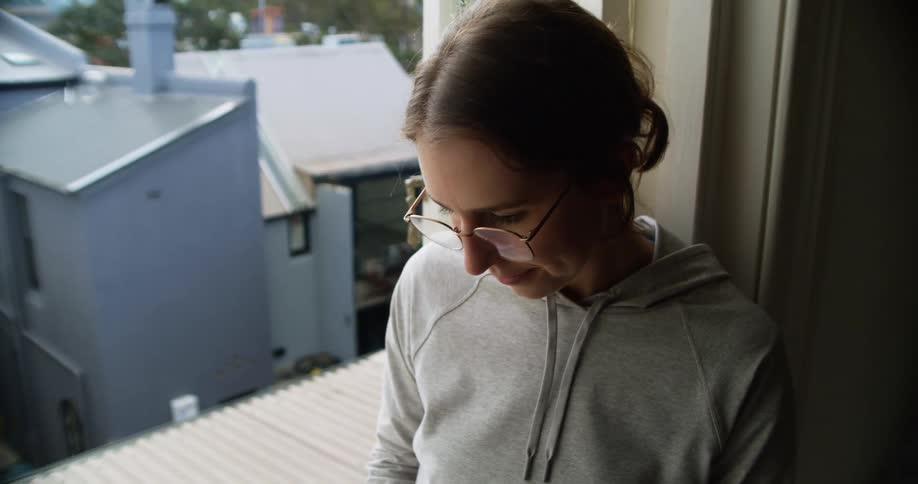 A woman sitting in her window in her apartment
