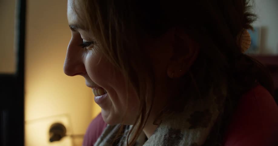 Woman sips coffee and laughs and smiles while texting on cell phone