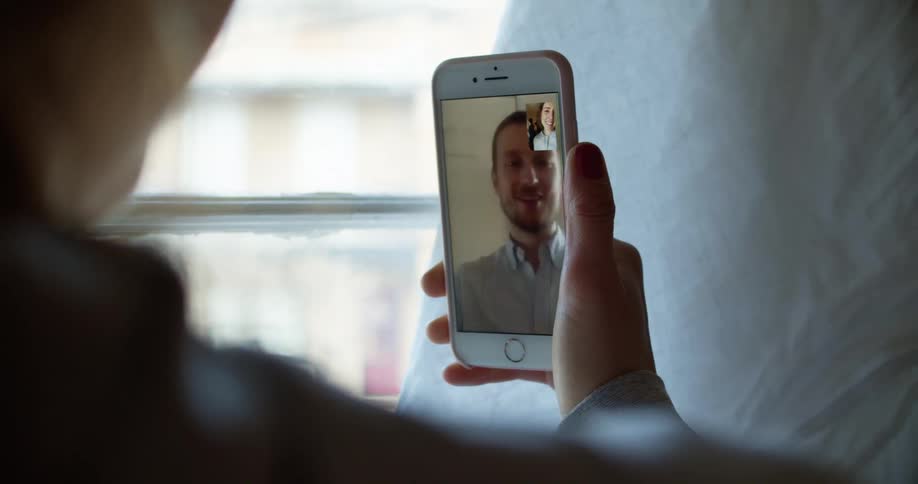 Woman holding phone has video call with man