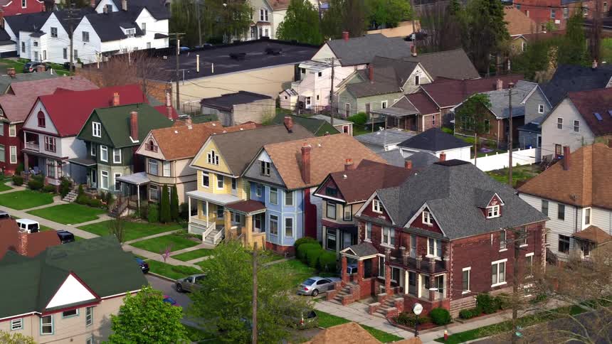 Trees park on street in neighborhood of two story homes