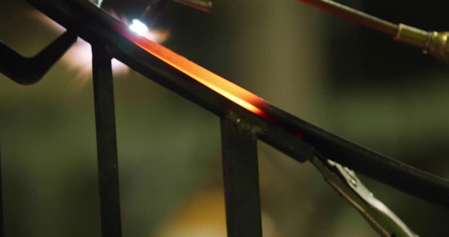 Metal is being bent with a torch