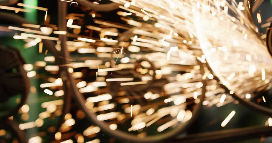 Sparks fly as iron is welded in a factory