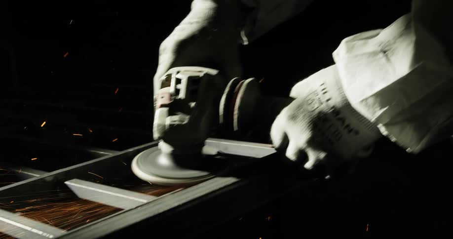 Person sanding down metal with flying sparks