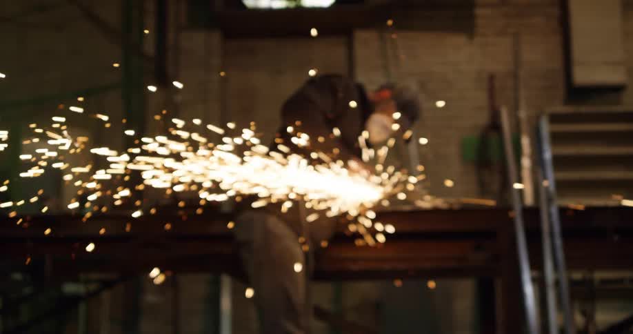 Sparks fly as a welder uses a grinder on a piece of metal